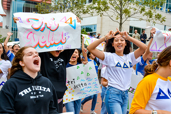 Students from sorority Tri Delta walk in the parade